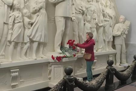 Москвичи и гости столицы несут цветы к восстановленной скульптурной группе с И.В. Сталиным