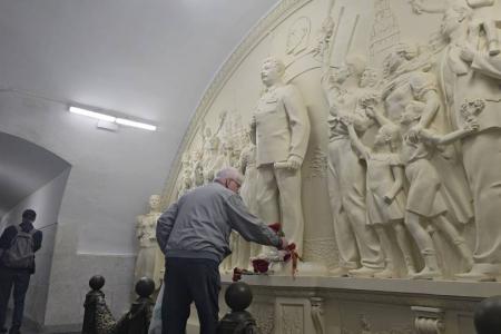 Москвичи и гости столицы несут цветы к восстановленной скульптурной группе с И.В. Сталиным